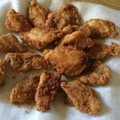 fried chicken pieces are on a white towel