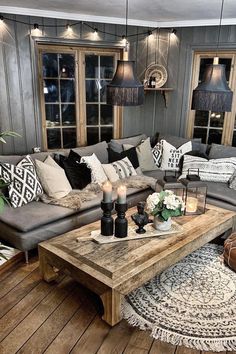 a living room filled with lots of furniture and pillows on top of a wooden floor