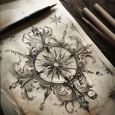 an artistic drawing on paper with pen and ink next to it is a compass tattoo design