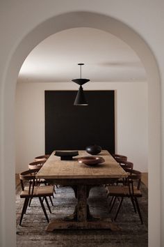 a dining room table and chairs with an arch in the middle