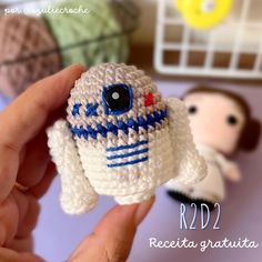 a hand holding a small crocheted star wars character