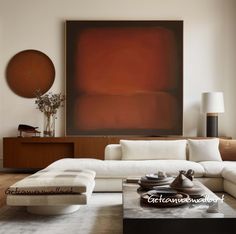 a living room filled with furniture and a large painting on the wall above it's coffee table