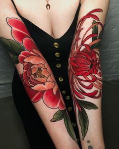 a woman with red flowers on her arms and arm sleeve tattoos, all done by the same person