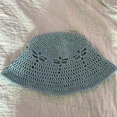 a crocheted hat laying on top of a bed