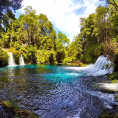 there is a waterfall in the middle of this river and it's blue water