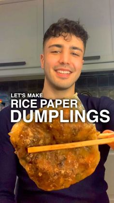 a man holding up a large piece of food with chopsticks in his hands