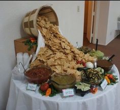 a table with chips, salsa and other foods on it