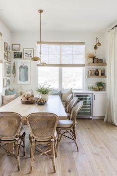 a dining room table with chairs and pictures on the wall