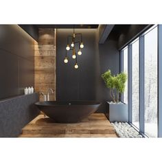 a large black bath tub sitting inside of a bathroom next to a wooden floor and wall