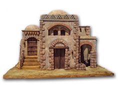 a small model of a building made out of bricks and stone, with stairs leading up to the front door