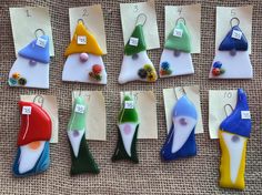 there are many different shapes and sizes of earrings on the display table with numbered cards attached to them