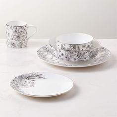 a white table topped with plates and cups filled with saucer, cup and saucer