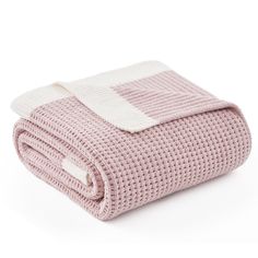 the pink and white blanket is folded on top of each other, with two rows of squares