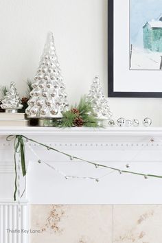 a mantel decorated with christmas trees and pine cones