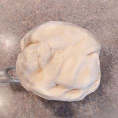 a ball of dough sitting on top of a glass bowl