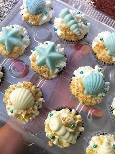 cupcakes with blue and white frosting in a plastic container