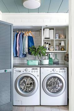 a washer and dryer in a small room with open shelves on the wall