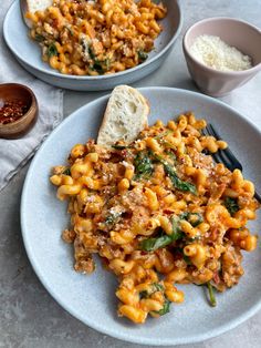 two plates with pasta and bread on them