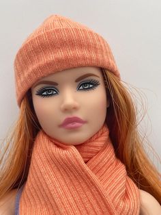 a doll wearing an orange scarf and hat