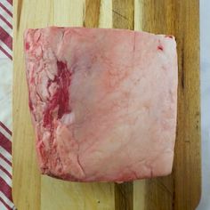 a piece of raw meat sitting on top of a wooden cutting board