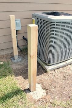 an air conditioner sitting next to a wooden post