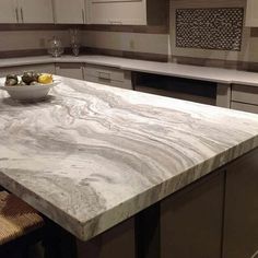 a bowl of fruit is sitting on the counter top in this modern style kitchen setting