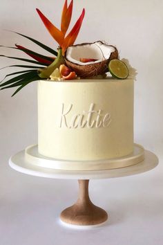 a white cake with coconuts and flowers on top that says kaute next to it