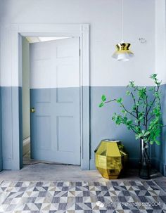 an image of a room with blue walls and yellow vases on the floor in front of it