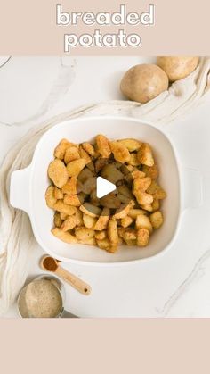 breaded potatoes in a white bowl on top of a table next to other ingredients