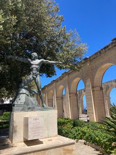 the statue is in front of an archway