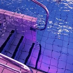 an empty swimming pool with steps leading up to the water's edge and blue tiles on the floor