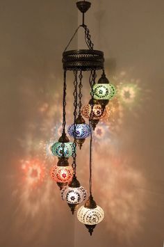 a chandelier hanging from the ceiling with many colorful lights on top of it