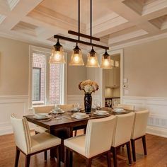 a dining room table with chairs and lights