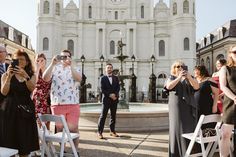 a group of people taking pictures in front of a building