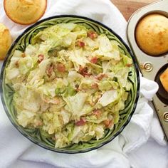 a bowl filled with coleslaw next to muffins