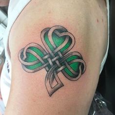 a green and black tattoo design on the thigh