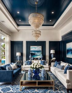 blue and white living room with chandelier, couches, coffee table and painting