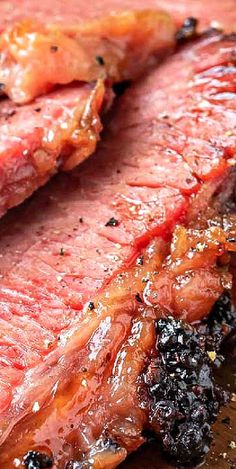 closeup of sliced meat with black pepper on the side and seasoning around it