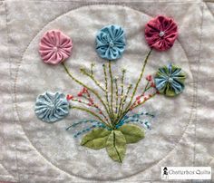 a close up of a piece of cloth with flowers on it and leaves in the center