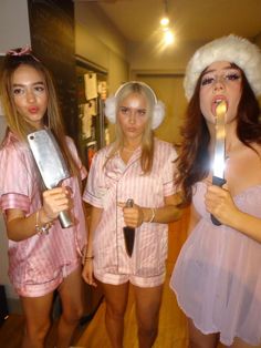 three women dressed in pink and white posing for the camera while holding utensils