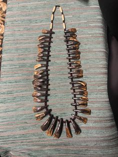 the necklace is made out of wood and has beads that are hanging from it's sides