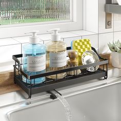 a sink with soap, hand sanitizers and other bathroom items on the tray