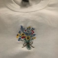 a white t - shirt with flowers on it