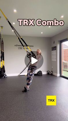 a woman is doing aerial exercises in the gym with an extra pull rope and handles