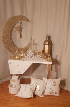 a white table topped with pillows next to a moon and star decoration on top of it