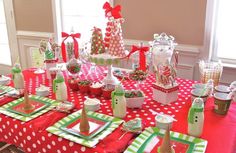 a table set up with red and green napkins, candy bars, cups and bottles