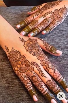 two hands with henna tattoos on them