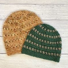 two crocheted hats sitting next to each other on top of a wooden table