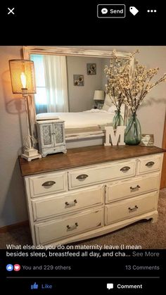 a bedroom with a dresser, mirror and lamp