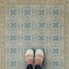 a person standing on top of a tiled floor next to a blue and white wall